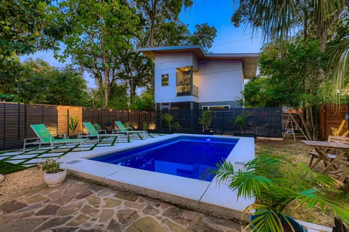 Refreshing pool surrounded by greenery and lounge chairs.