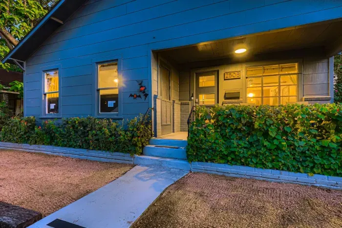 Welcoming front entrance with cozy porch details and greenery.