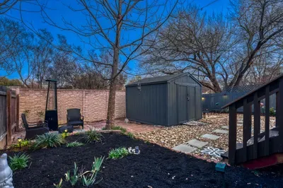 Backyard retreat with fire pit, lounge chairs, and soft landscape lighting