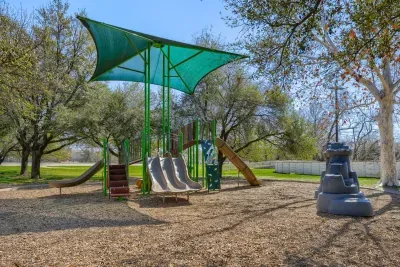 Family-friendly playground with slides, climbing features, and shaded seating