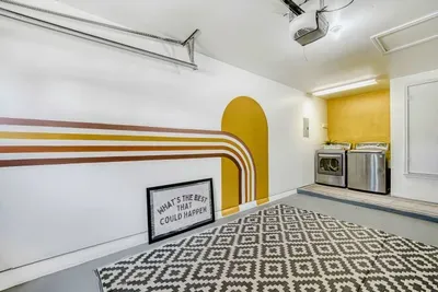 Playful laundry space with bold mural, full size washer and dryer, and a design that makes everyday tasks feel a little lighter