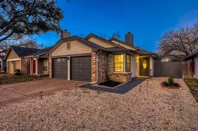 Warm, inviting entry glows at dusk with private front access and garage parking