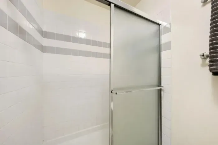 Clean glass-enclosed shower with modern tile design.