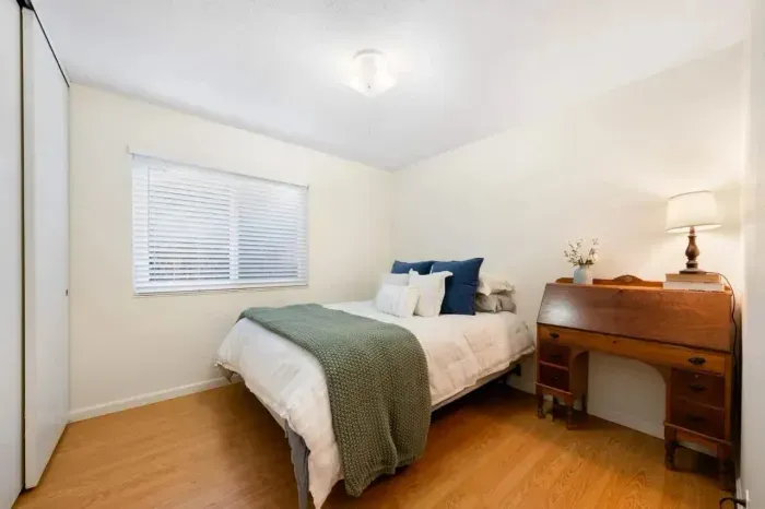 Bright bedroom offering privacy, comfort, and storage space.