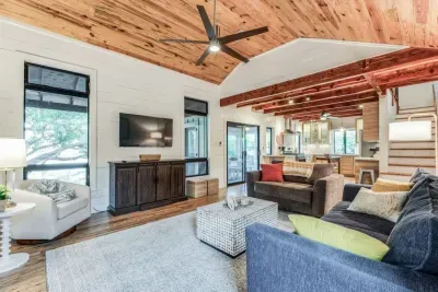 Spacious living room with vaulted wood ceilings, large smart TV, and plenty of cozy seating for family gatherings.