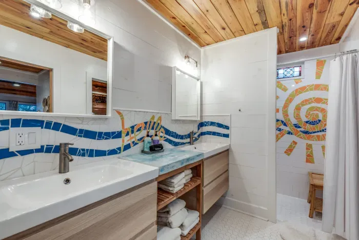 Bright bathroom with double sinks and creative tilework.