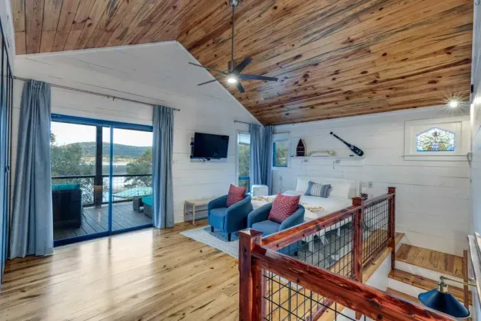 Bright loft-style living area with vaulted wood ceilings.