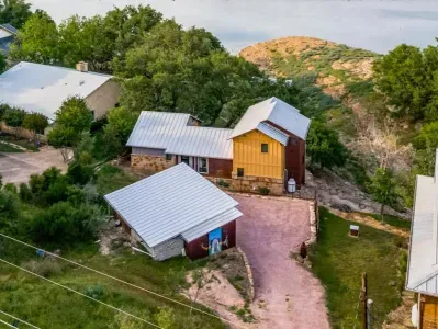 Scenic exterior view with private driveway access, hillside backdrop, and spacious covered carport