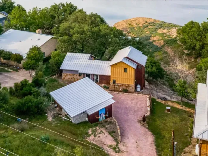 Scenic exterior view with private driveway access, hillside backdrop, and spacious covered carport