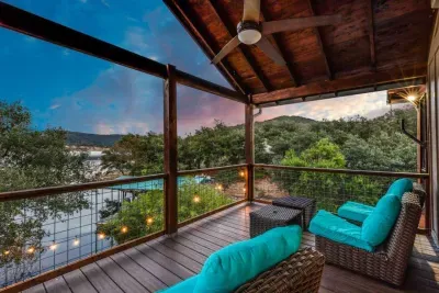 Covered balcony with cozy seating overlooking the water.