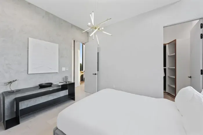 Recharge in a serene bedroom featuring a plush queen-size bed, modern lighting, and sleek design details
