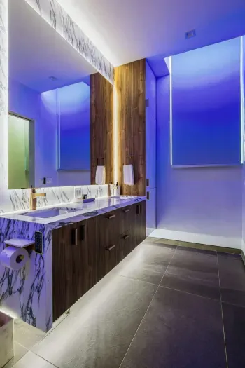 This modern bath features glowing accent lighting and a double vanity, perfect for couples or families getting ready with ease