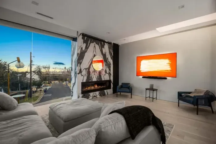 Kick back on oversized sofas, cozy up by the fireplace, and enjoy movie nights on the big screen with sunset views just outside