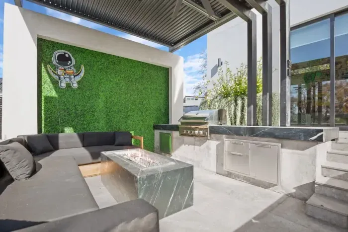 Vibrant backyard with outdoor kitchen and lounging area with a colorful mix of plants and flowers, creating a bright and cheerful atmosphere.