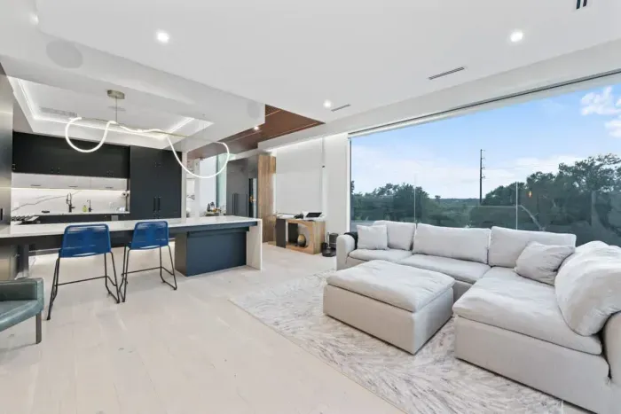 Enjoy a bright, open-concept living space with floor-to-ceiling windows, a modern kitchen, and comfortable lounge seating