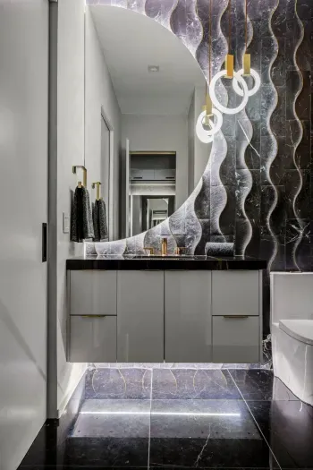 Enjoy a stylish bathroom with bold designer finishes, a sleek vanity, and modern lighting