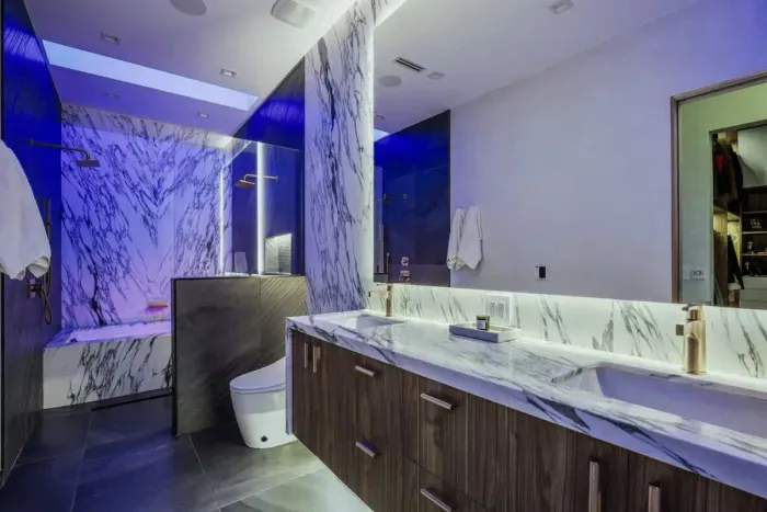 This stunning bathroom has it all! A double vanity, luxurious soaking tub, rainfall shower, and modern lighting to set the mood.