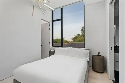 Natural light floods this charming room, complete with a queen-size bed and stylish furniture, making it the perfect spot for a peaceful stay.