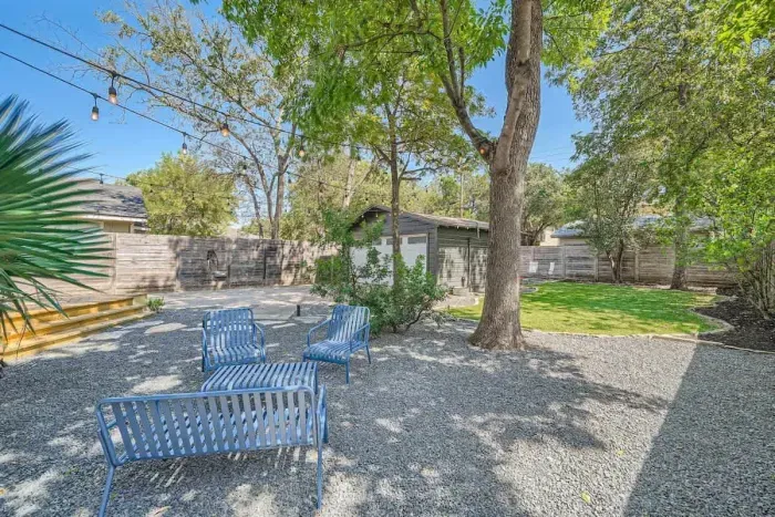 Cozy backyard retreat with string lights, a fire pit, and comfortable seating.
