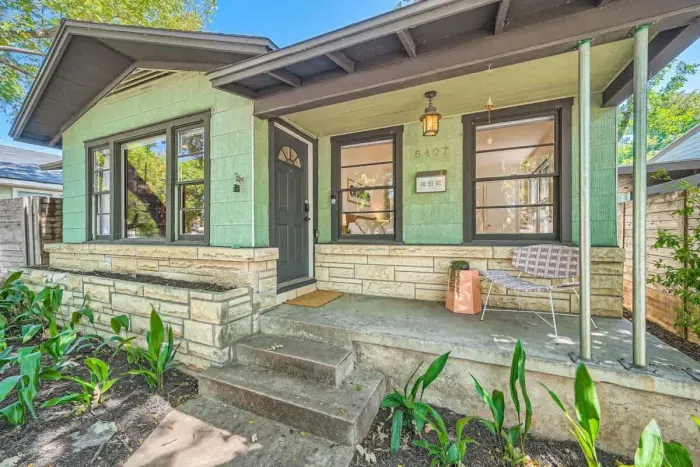 Inviting front yard with mature trees, a lovely garden, and a peaceful atmosphere.