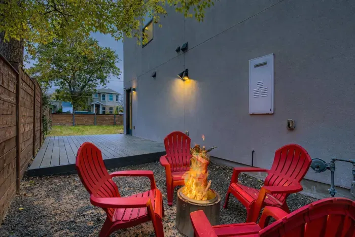 Backyard fire pit with lounge chairs.