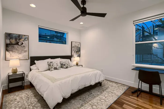 Guest bedroom with ceiling fan and TV
