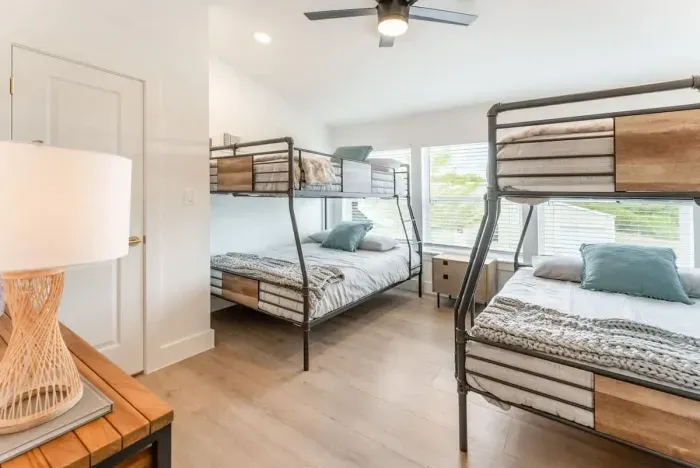 Rest easy in a serene guest suite featuring designer bunk beds and warm natural light