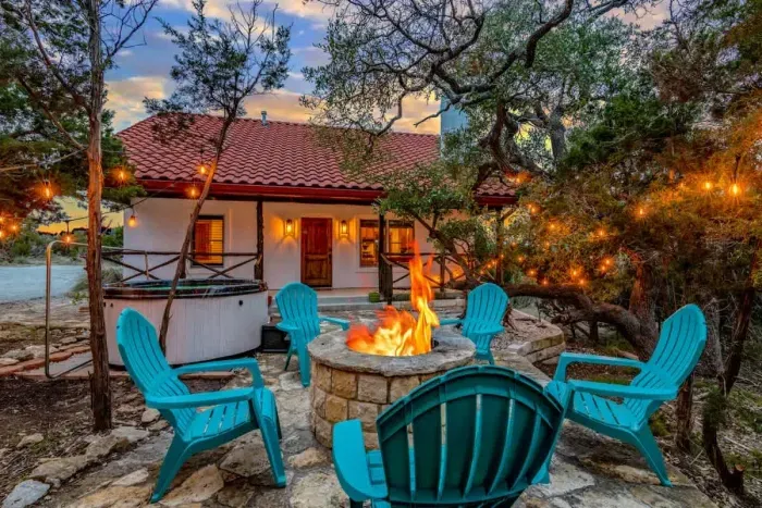 Cozy backyard retreat with string lights, a fire pit, and comfortable seating.