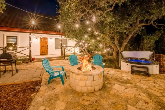Cozy backyard retreat with string lights, a fire pit, and comfortable seating.