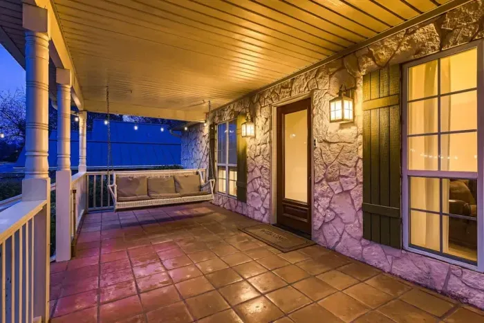 Unwind on this charming covered porch, complete with a cozy swing and warm, ambient lighting. Perfect for relaxing evenings or morning coffee, just steps from your home away from home.