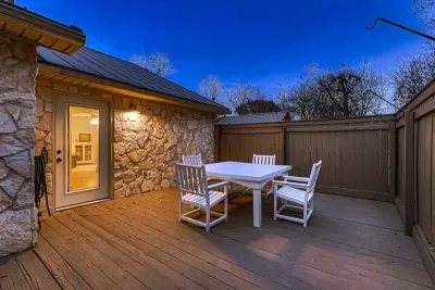 The expansive deck features a dining table, perfect for enjoying a meal al fresco in the warm weather.