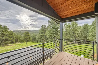 Relax on the patio during the summer months, surrounded by vibrant green trees and a well-kept lawn. The clear blue sky overhead creates the perfect setting for outdoor dining or unwinding in the sunshine.