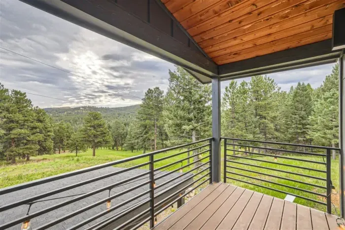 Relax on the patio during the summer months, surrounded by vibrant green trees and a well-kept lawn. The clear blue sky overhead creates the perfect setting for outdoor dining or unwinding in the sunshine.