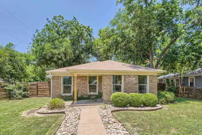 Spacious front yard with beautiful greenery and inviting entry.