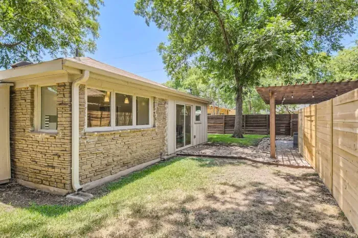 Spacious yard with lush greenery, perfect for kids to play or for lounging.