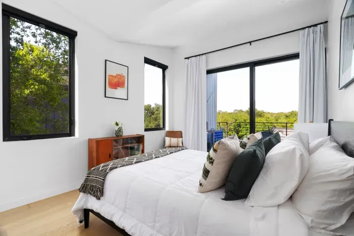 A modern queen-size bed, neutral decor, and artistic touches make this room an effortlessly chic and peaceful escape.