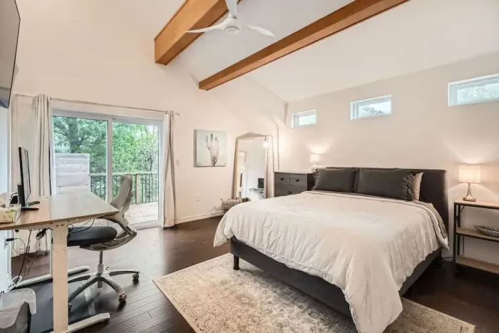 4. Spacious primary bedroom with a king-sized bed and an en-suite bathroom.