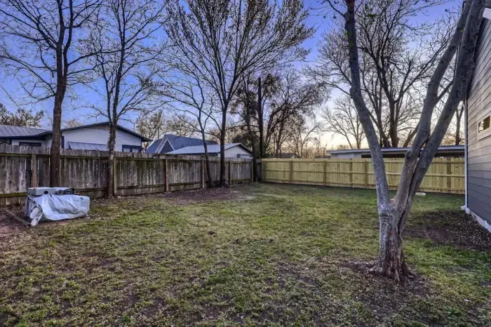 Well-maintained backyard with a variety of trees and shrubs for a natural, private setting.