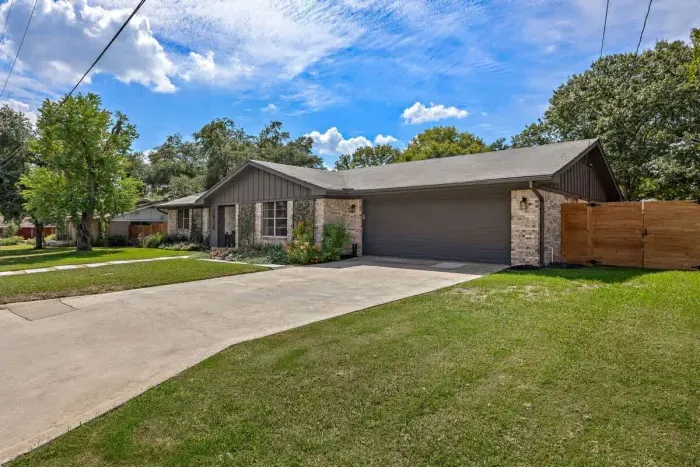 Inviting front exterior with a spacious driveway and well-kept lawn.