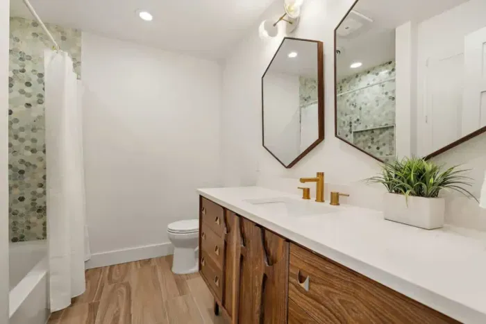 Elegant full bath featuring stylish mirrors that enhance the modern design. With sleek fixtures and a chic aesthetic, this bathroom offers both functionality and visual appeal. Perfect for a spa-like experience, it’s a beautiful space for relaxation