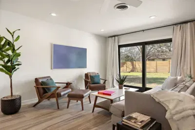 Spacious living room with a large window offering stunning views of the outdoors. The natural light floods the room, creating a bright and airy atmosphere. Perfect for relaxing or entertaining, this inviting space seamlessly connects with nature, pro