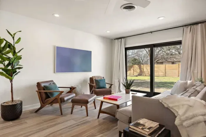 Spacious living room with a large window offering stunning views of the outdoors. The natural light floods the room, creating a bright and airy atmosphere. Perfect for relaxing or entertaining, this inviting space seamlessly connects with nature, pro