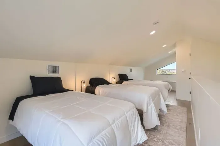 A clean, classic room with 3 single  beds and simple decor, offering a restful night’s sleep and relaxation.