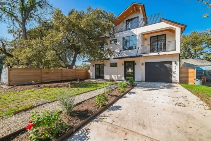 Inviting front entry with lush greenery and a well-maintained lawn.