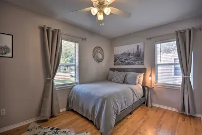 Bright guest bedroom with queen bed and large windows.