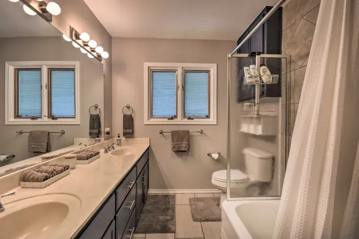 Modern bathroom with double vanity and shower/tub combo.