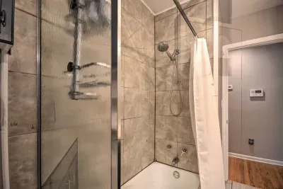 Modern bathroom with tiled shower and glass doors.