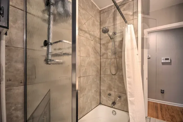 Modern bathroom with tiled shower and glass doors.