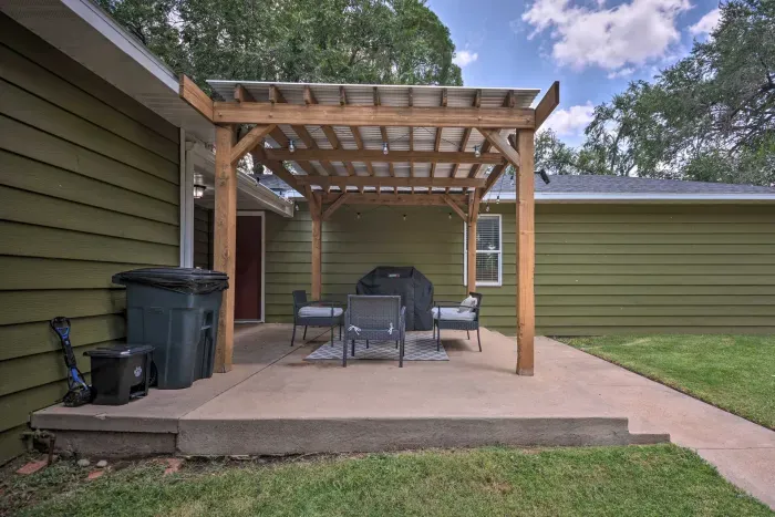 Shaded backyard patio with pergola and outdoor seating.