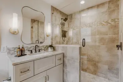 Spa-like primary bathroom with a walk-in glass shower and warm, timeless finishes